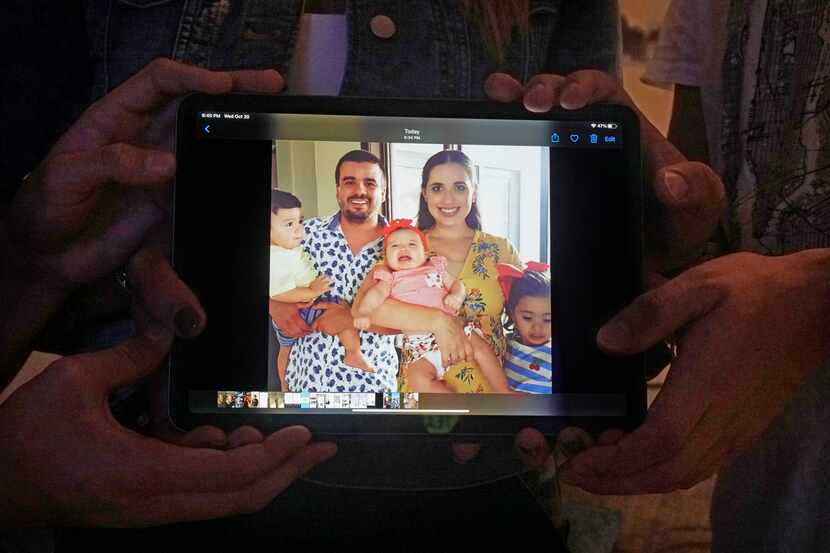 Andrea Domínguez y su familia sostienen una foto de su hermana Gabriela Garzón, su esposo y...