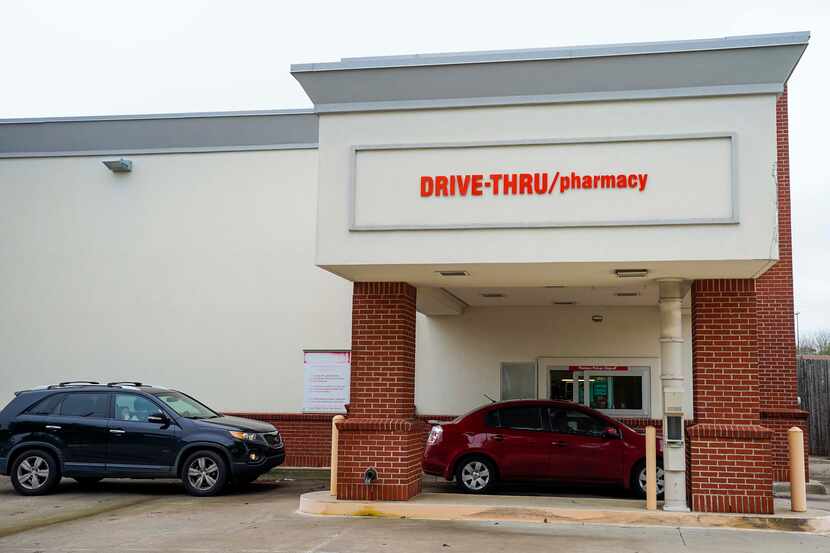Cars line up for drive-thru service at a CVS pharmacy on Belt Line Road in Dallas on March...