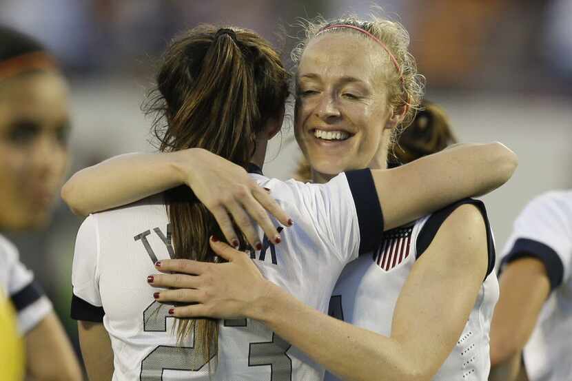 U.S. midfielder Erika Tymrak (23) gets a hug from defender Becky Sauerbrunn (4) after...