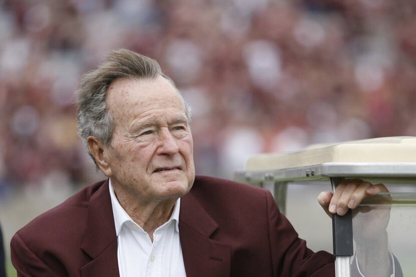 President George H.W. Bush stood with his hand over his heart during the national anthem...