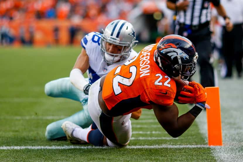 DENVER, CO - SEPTEMBER 17:  Running back C.J. Anderson #22 of the Denver Broncos rushes past...