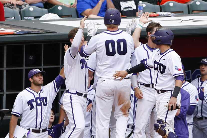 TCU's Kevin Cron (00) celebrates with his team after scoring a run in the third inning of...