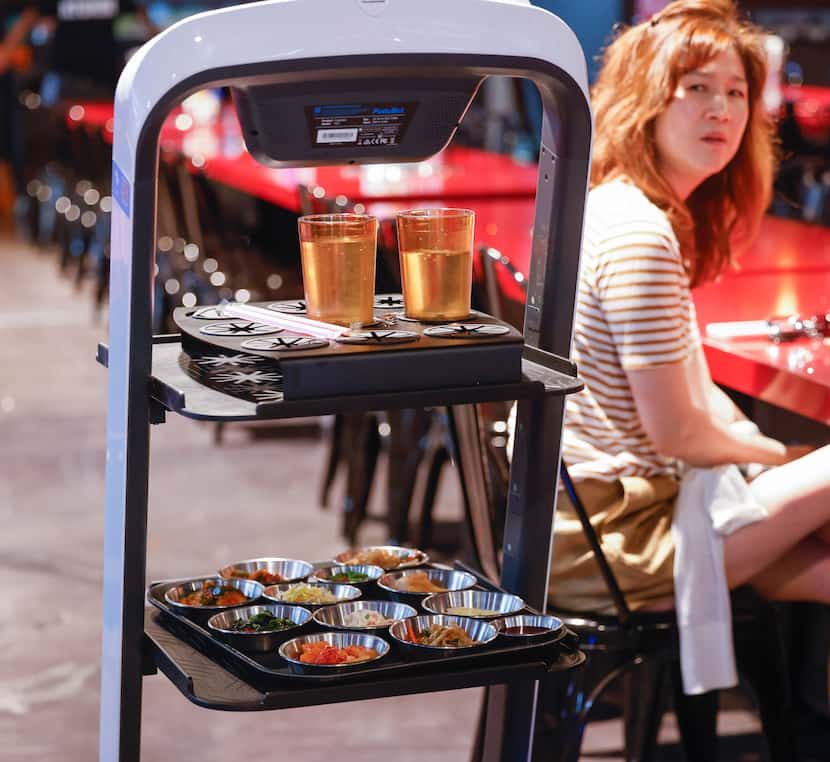 A robot delivers food to the tables at Moo Dae Po Korean barbecue restaurant.