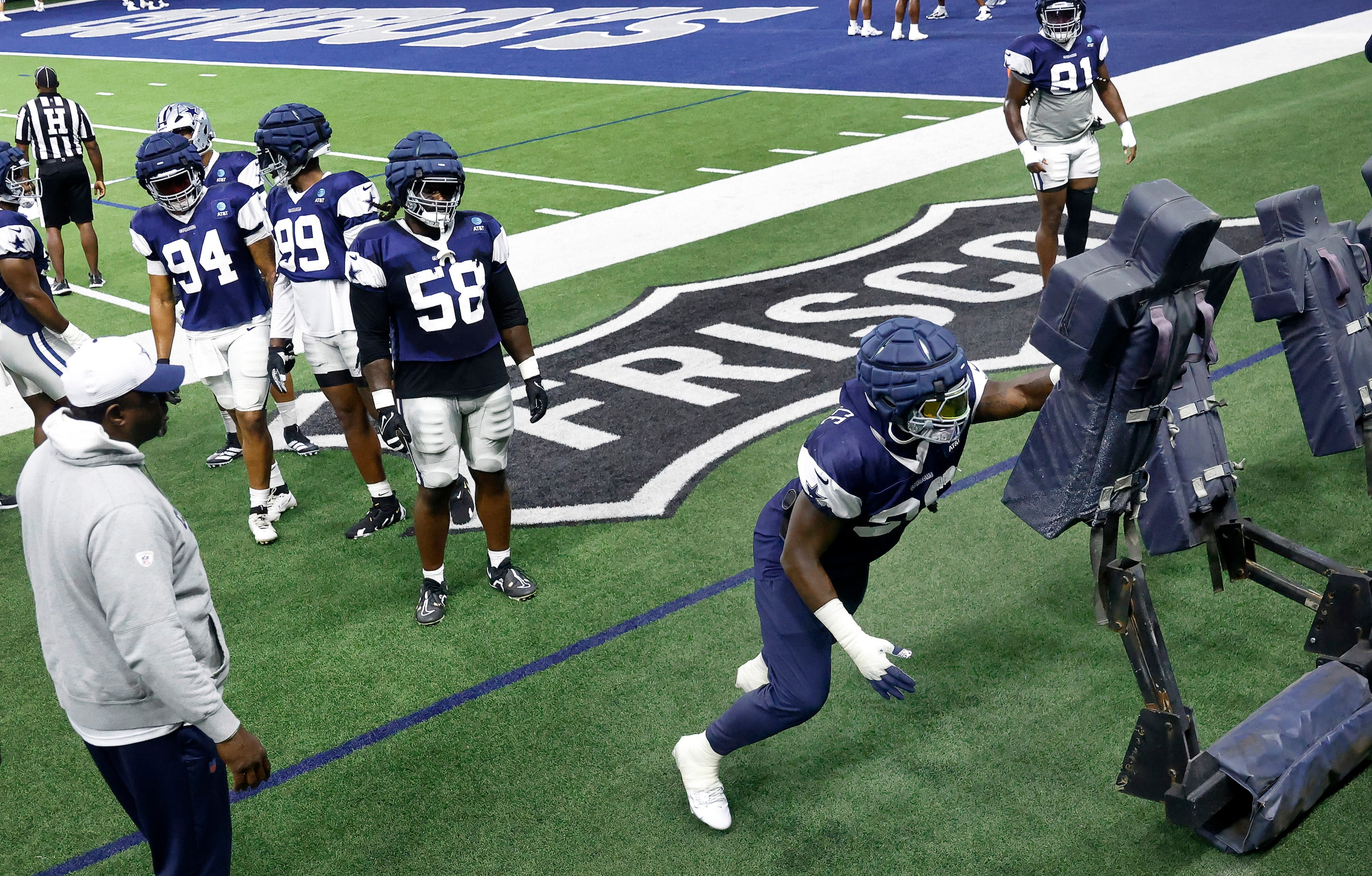 Dallas Cowboys defensive end DeMarcus Lawrence (90) hits the blocking sled with one arm...