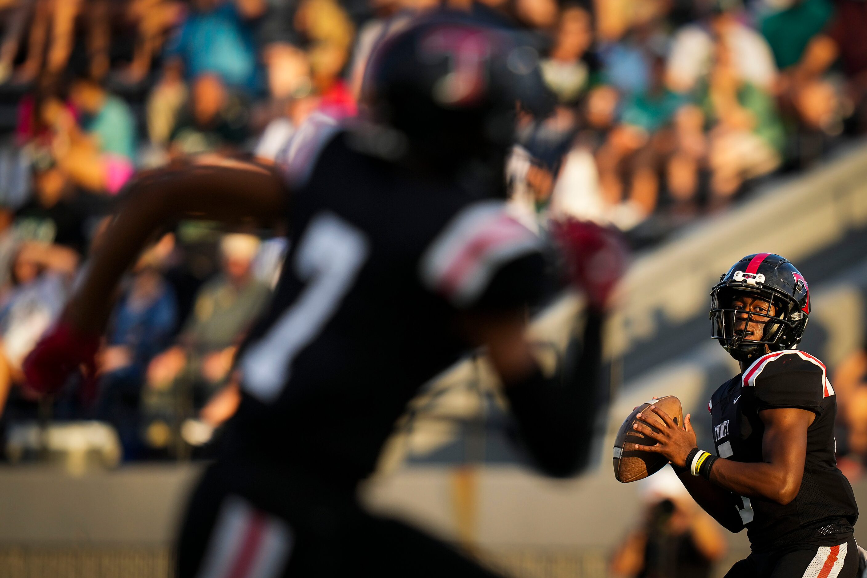 Euless Trinity quarterback Ethan Williams (5) looks toward wide receiver Nasir Allah (7)...