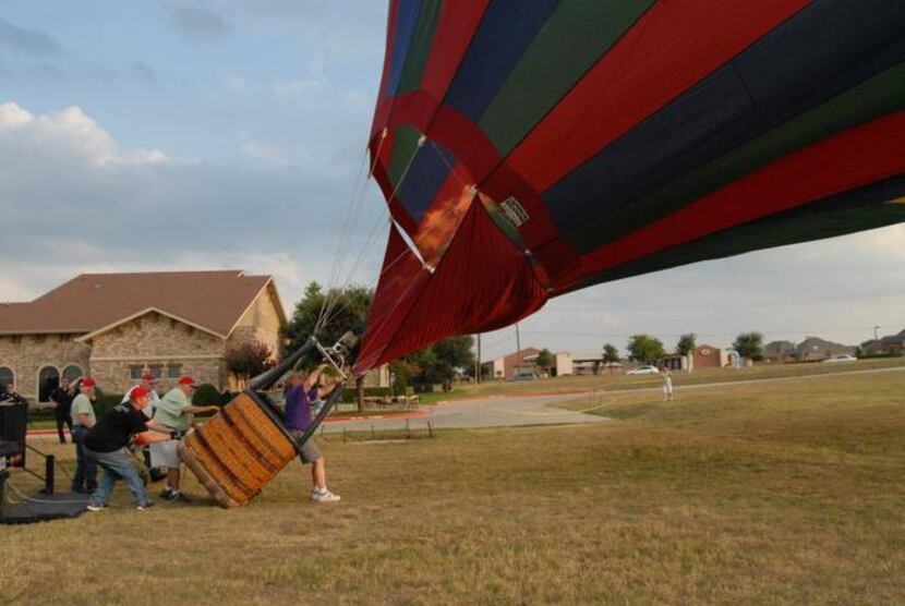 
Pat Cannon hits the burners to add hot air to his balloon, lifting the balloon to a...