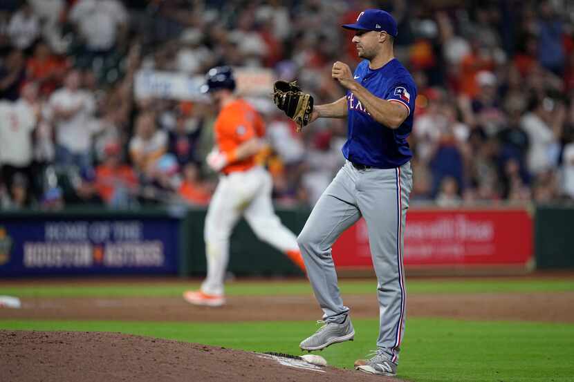 Texas Rangers relief pitcher Brock Burke reacts after giving up a two-run home run to...