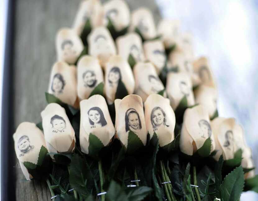 White roses with the faces of victims of the Sandy Hook Elementary School shooting are...