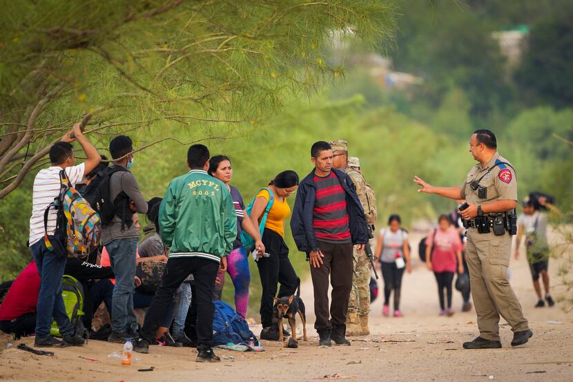 A Texas Department of Public Safety trooper talked to a group of migrants who turned...