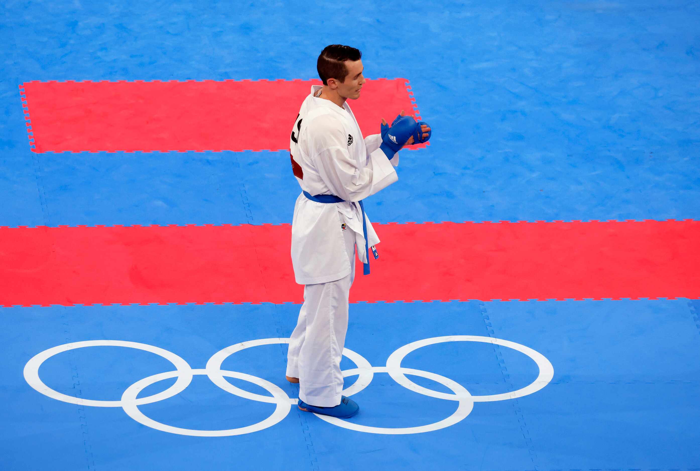 USA’s Tom Scott claps after defeating Egypt’s Abdalla Abdelaziz during the karate men’s...