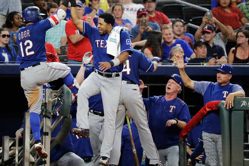 Texas Rangers' Rougned Odor, left, is high-fived by teammate Elvis Andrus after hitting a...