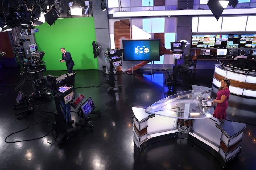 WFAA-TV chief meteorologist Pete Delkus (left) delivers his 5 p.m. weather forecast in front...