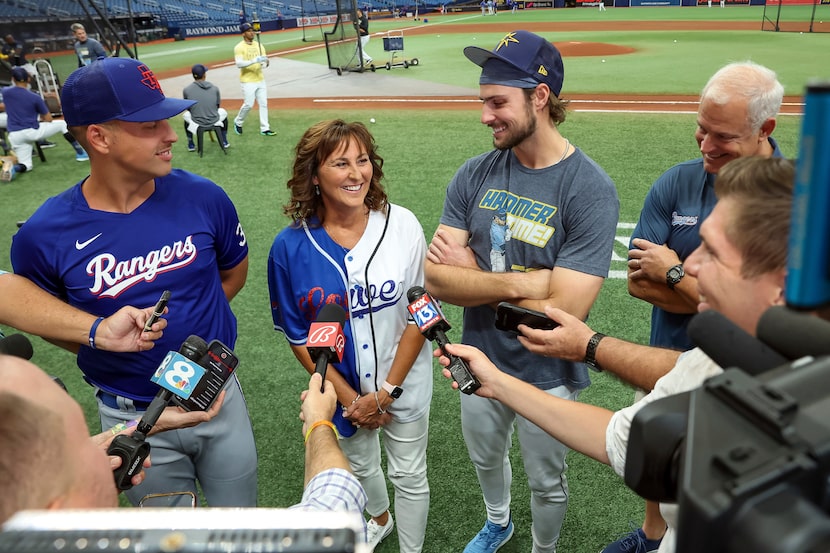 Texas Rangers' Nathaniel Lowe, left, and Tampa Bay Rays' Josh Lowe, third from left, talk to...