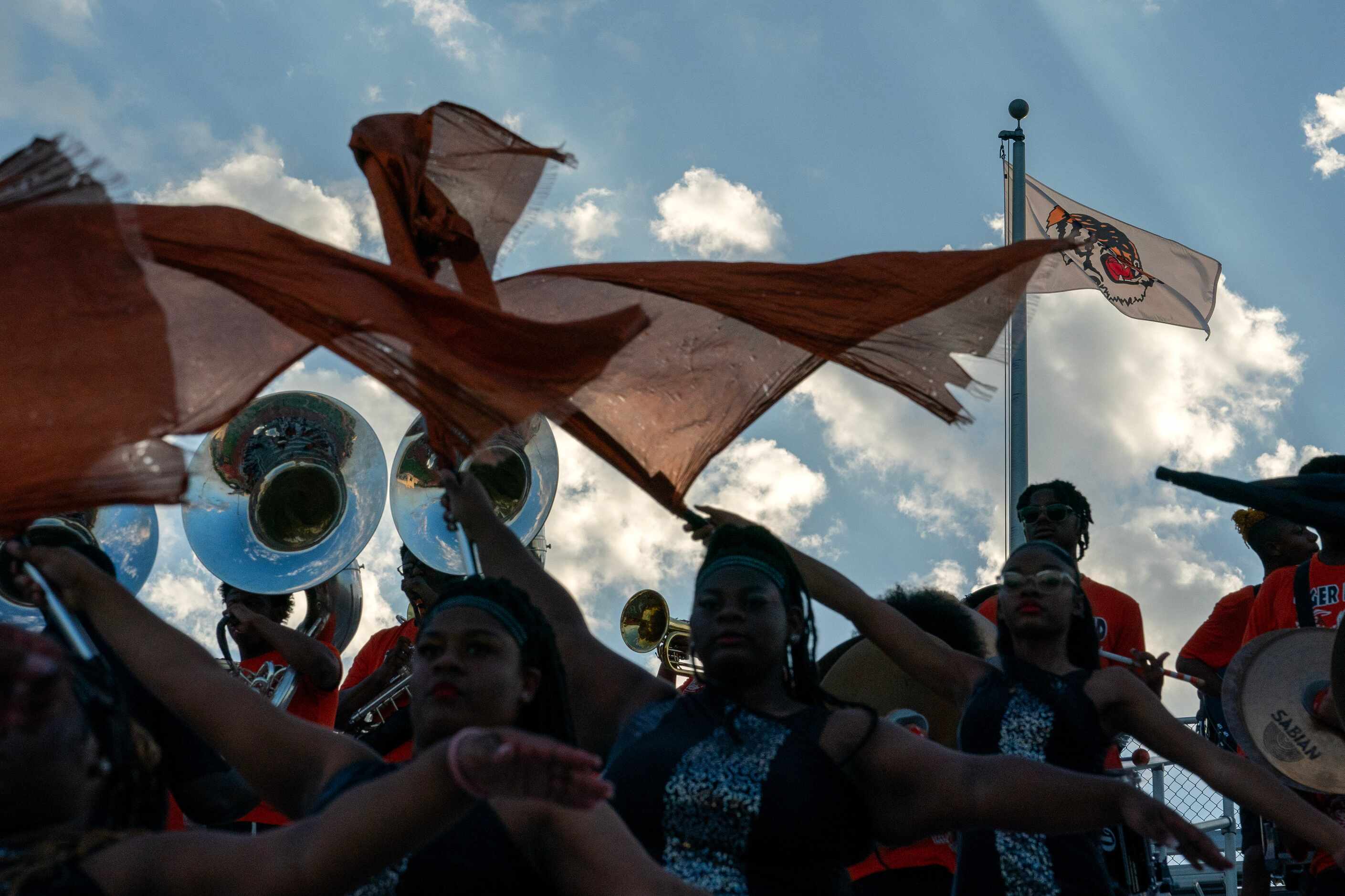 The Lancaster color guard waves flags as the band plays before a high school football game...