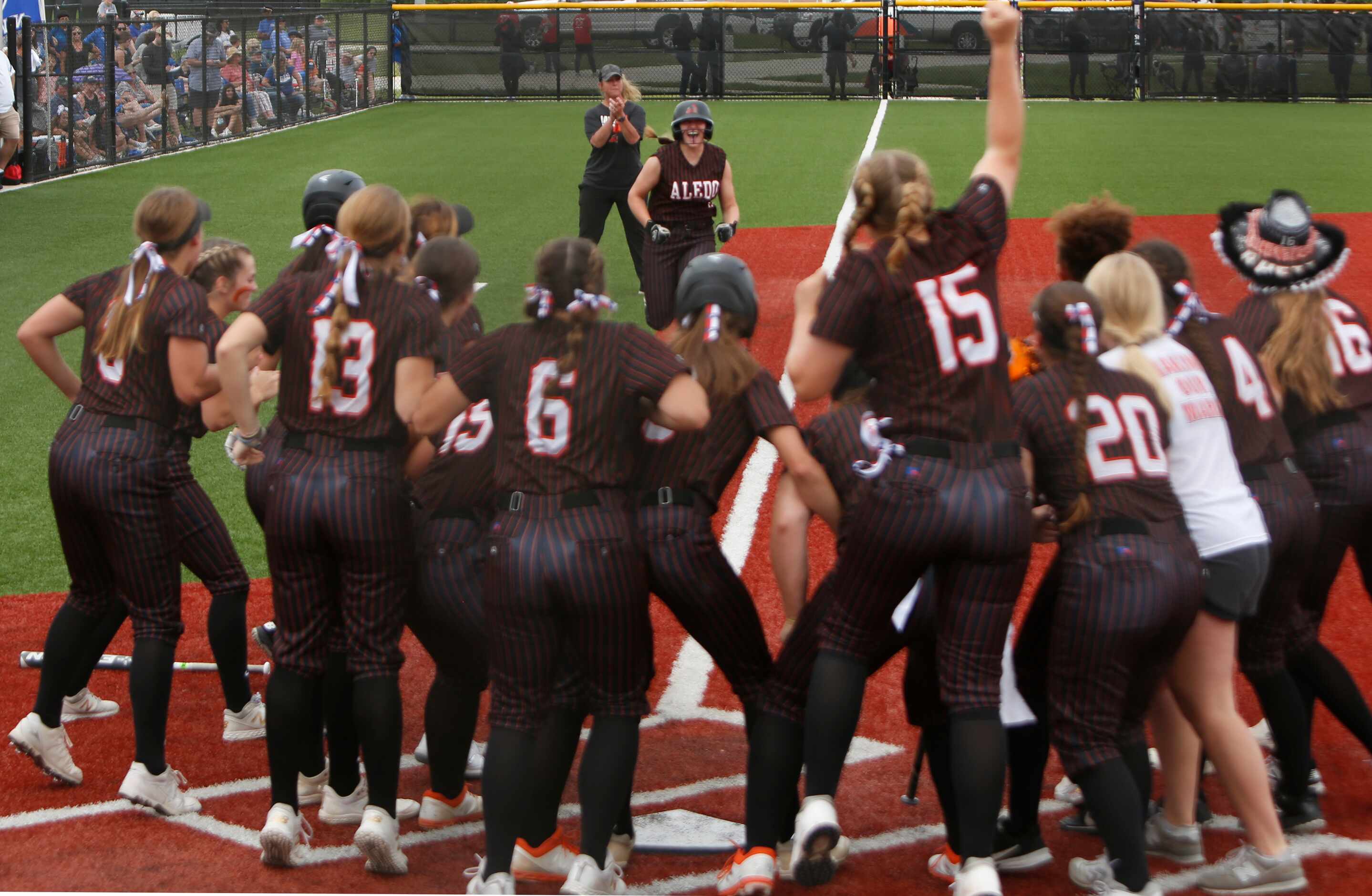 Aledo outfielder Marissa Powell (11) received quite the reception at home plate after...