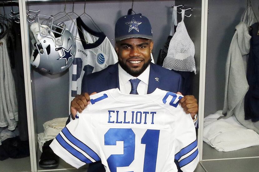 Ezekiel Elliott poses with his jersey in front of his locker at the team's training facility...