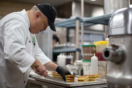 Senior Executive Chef Rudy Vasquez slices rosemary focaccia bread  at Kitchen West at the...