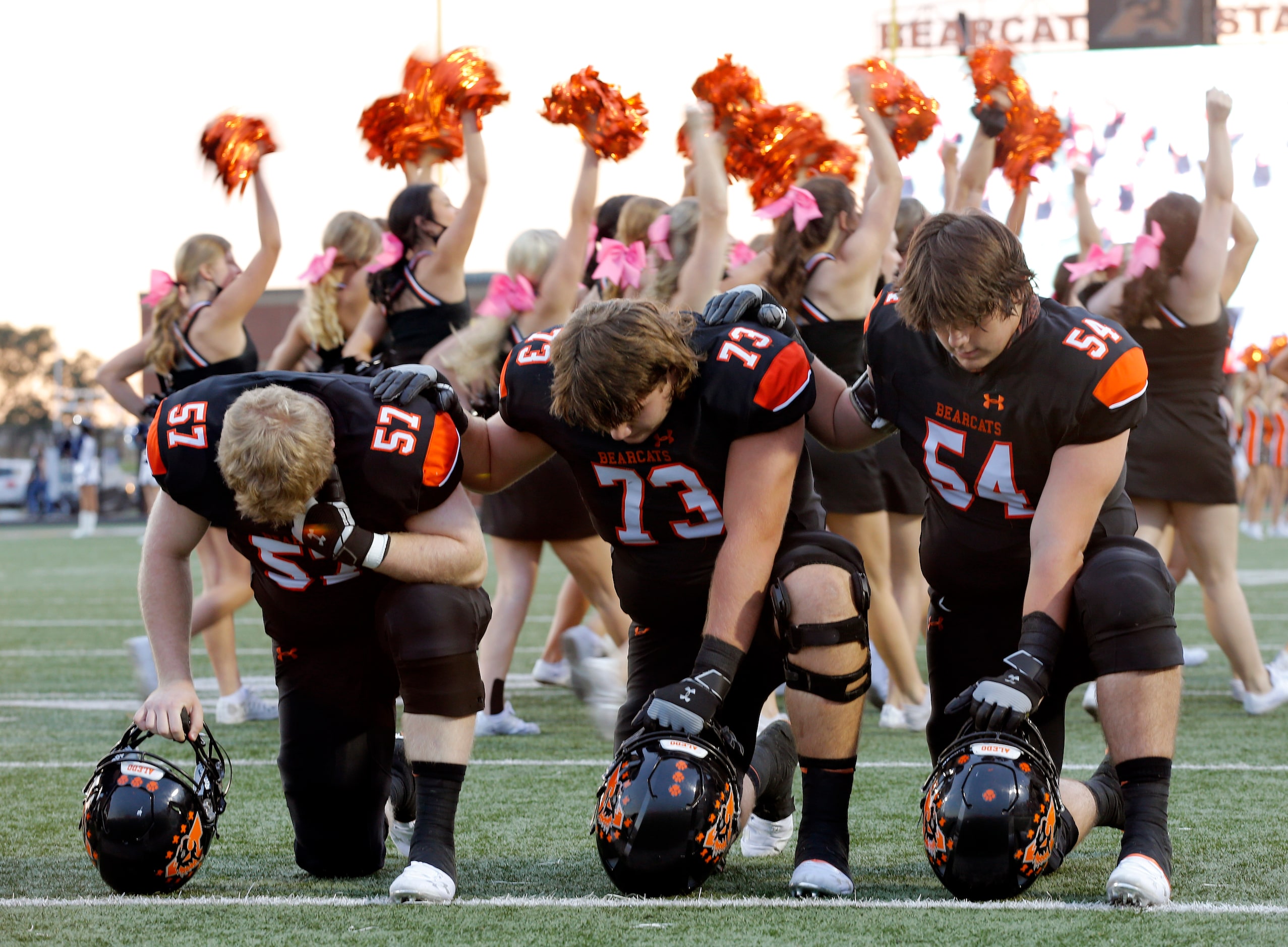 Aledo football players Brady Wood (57), Gunnar Allen (73) and Rocco O'Keefe (54) take a knee...