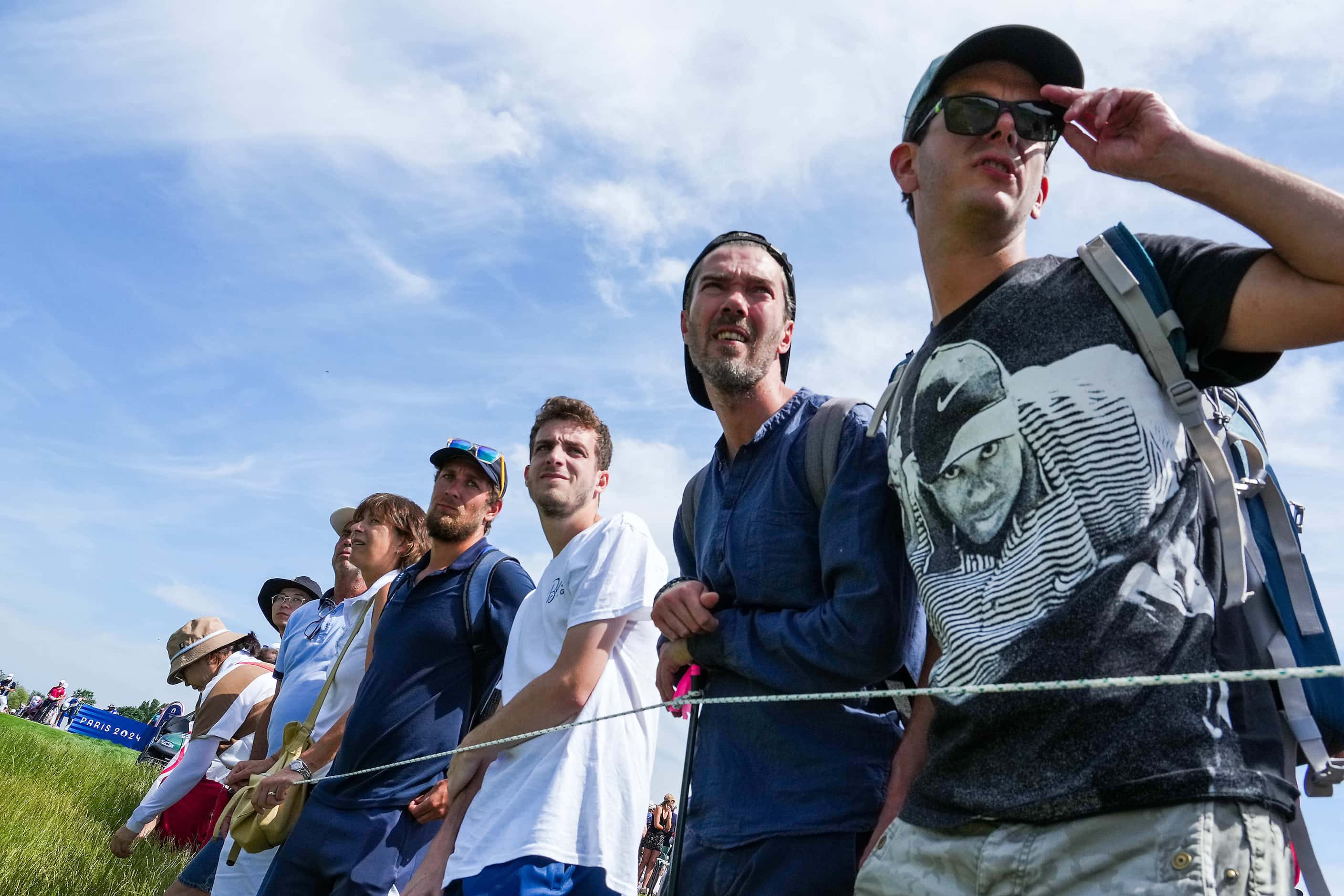 spectators watch a tee shot by Scottie Scheffler of the United States during the final round...