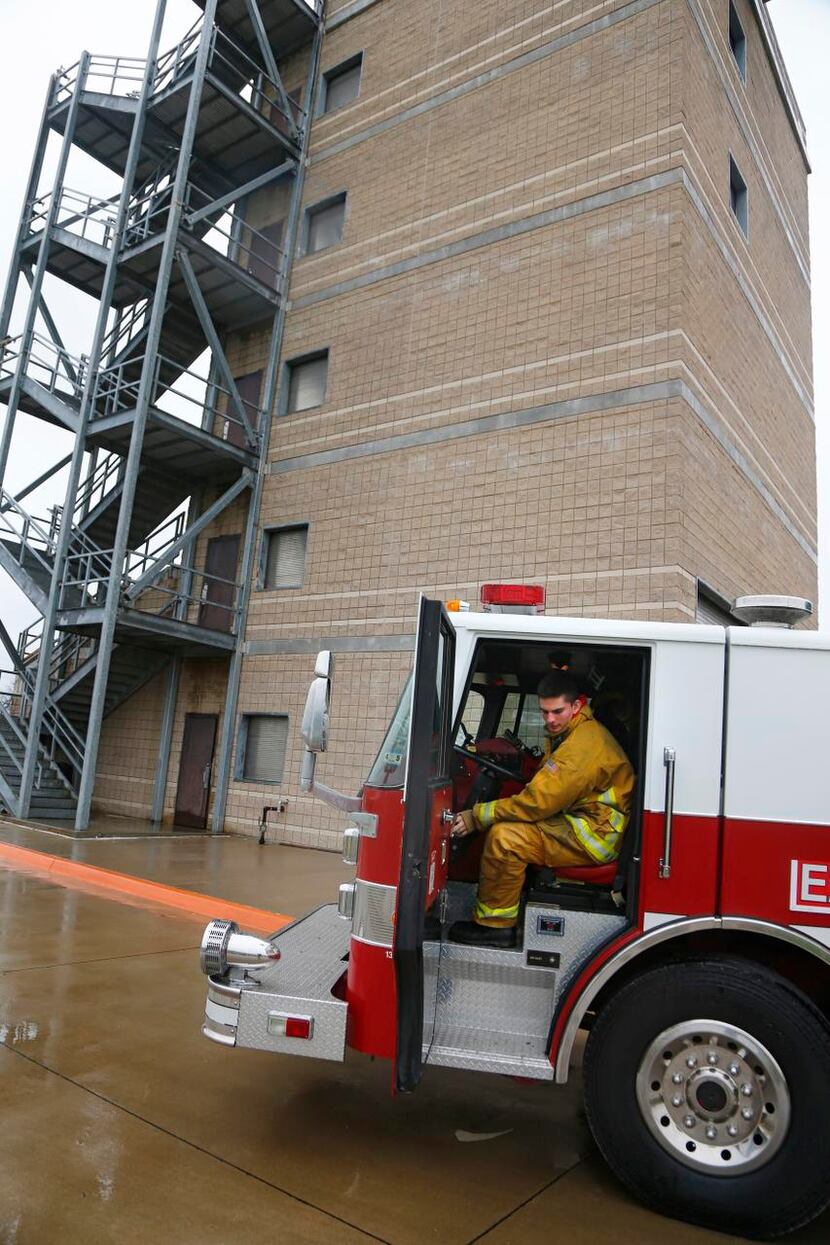 
 Wesberry jumps into a fire engine while training with other Garland firefighters in a...