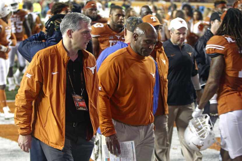 Texas coach Charlie Strong, center, walks off the field after Texas Tech defeated Texas...