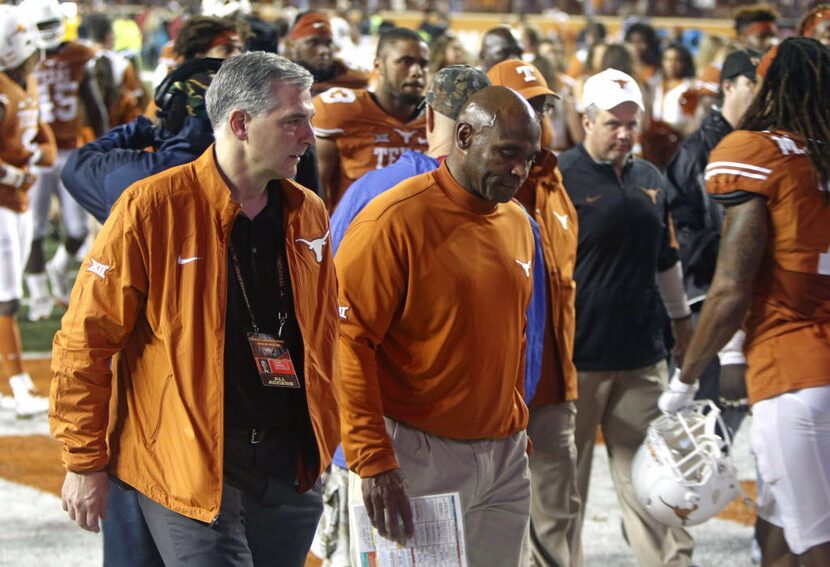 Texas coach Charlie Strong, center, walks off the field after Texas Tech defeated Texas...