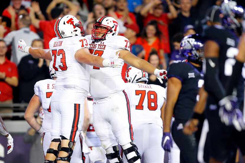 FILE - Texas Tech offensive linemen Dawson Deaton (73) and Jacob Hines (77) chest bump after...