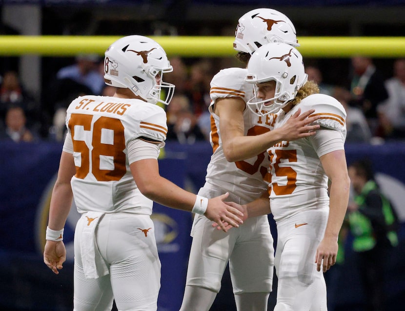 Texas place kicker Bert Auburn (45) is comforted by his teammates Texas safety Lance St....