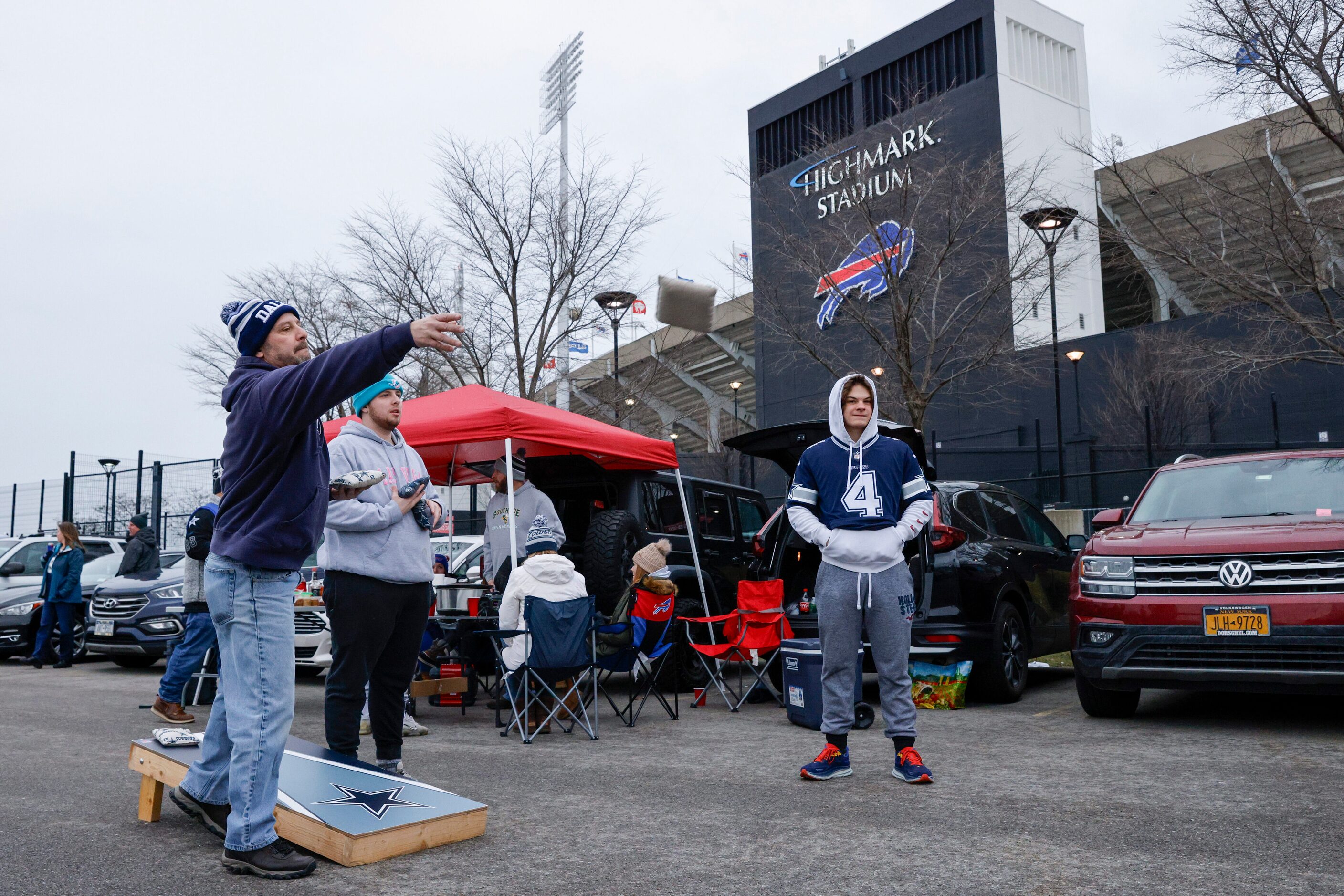 Jamie Matthews (left) plays cornhole with his son Andrew Matthews (second from left) outside...