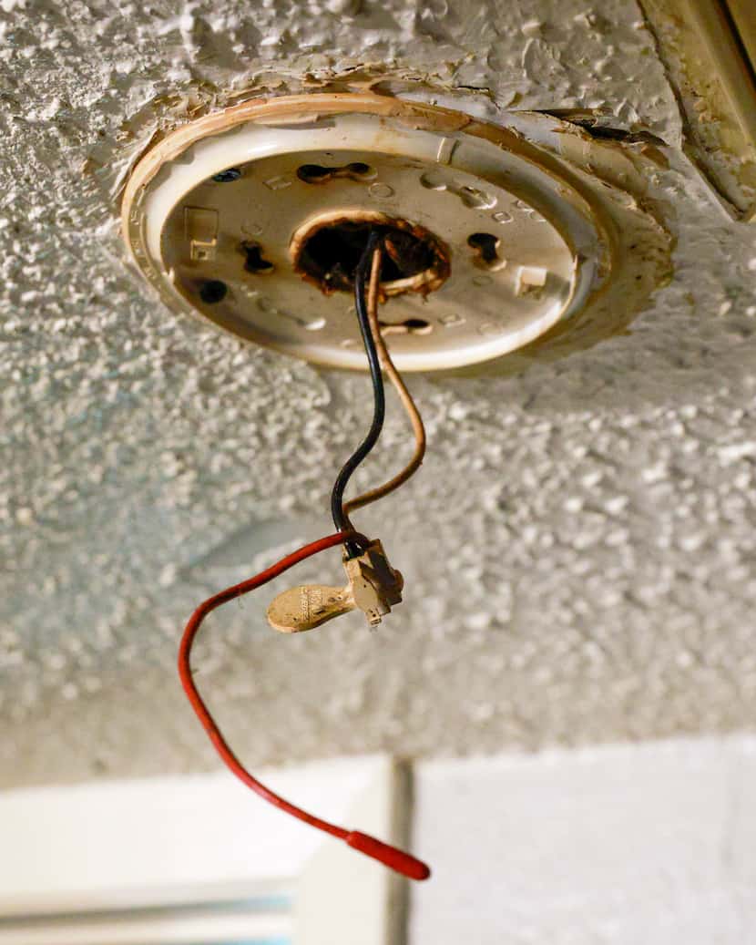 Wiring is exposed where a smoke alarm should be in the ceiling of Destiny Morris’ unit at...
