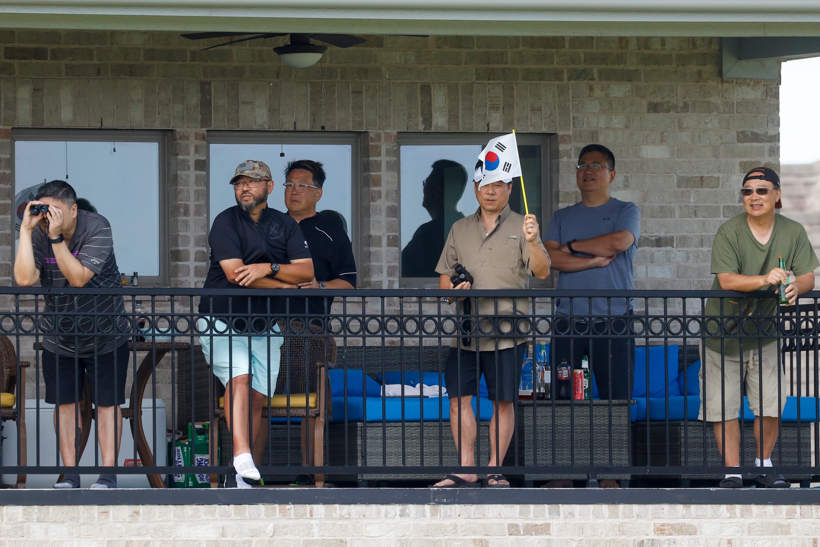 Fans watch action alongside the No. 2 green from a second floor balcony during the third...