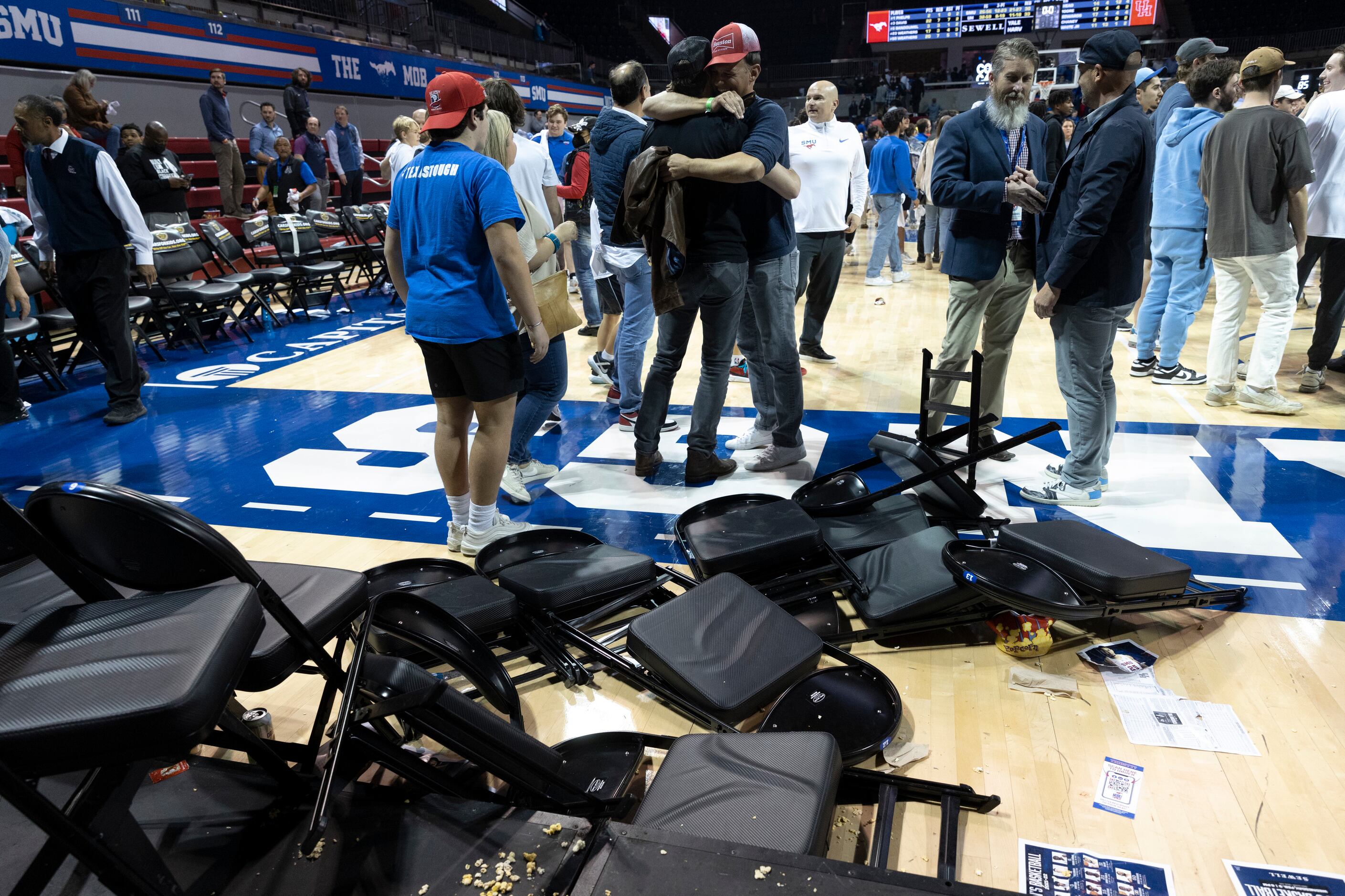 Chairs and popcorn scatter the floor after fans rush the court at the end of the game at...