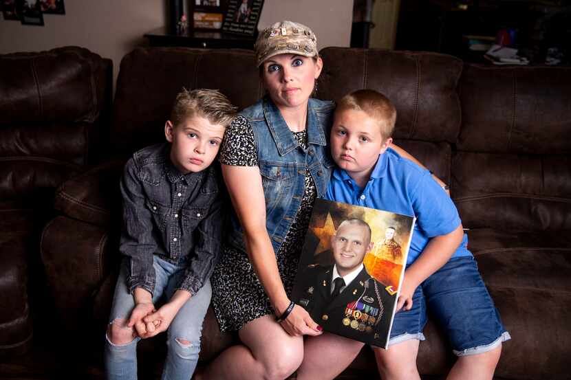Becky Welch poses with her sons Aaden Welch, 11, left, and Robby Welch, 9, with a portrait...