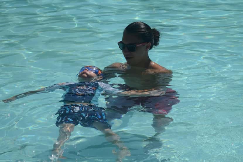 El salvavidas Israel Reséndiz también enseña natación a los niños en la alberca H.R. Moore,...