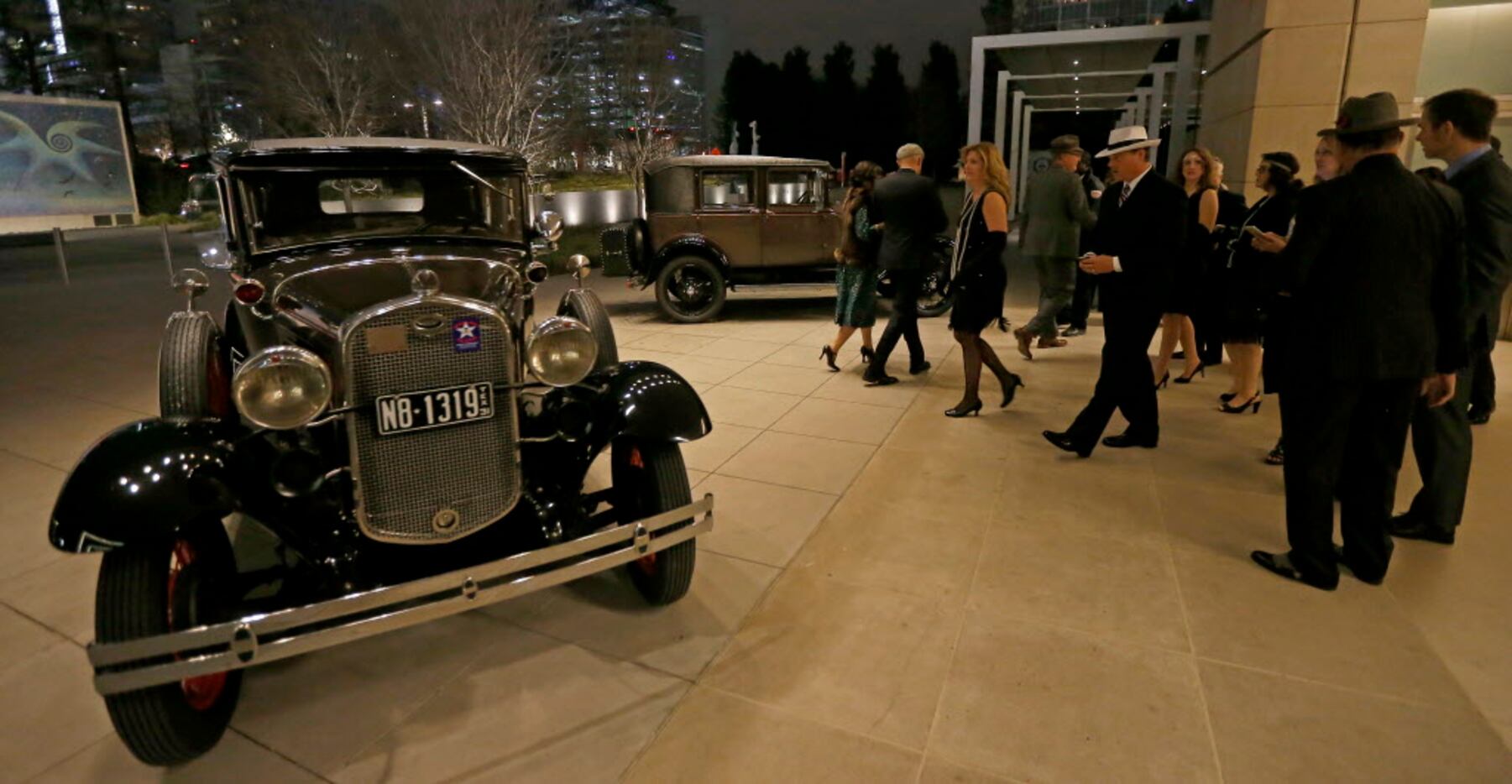 Guests look at antique cars including a 1931 Ford Deluxe Modal A Fodor Town Sedan (left)...
