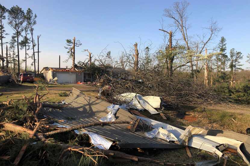 Debris covers the ground around a home that was damaged from severe weather in Wynne, Ark.,...