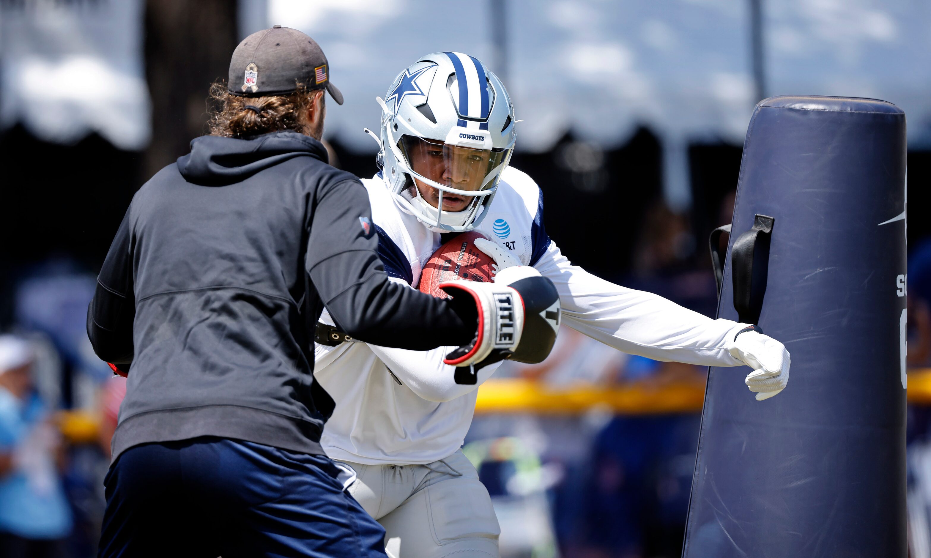 Dallas Cowboys running back Tony Pollard (20) runs through a punching drill as he maintains...