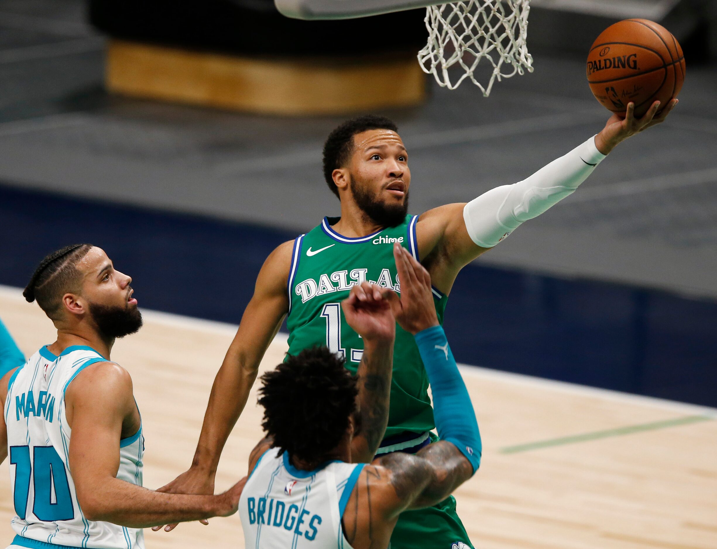 Dallas Mavericks guard Jalen Brunson (13) attempts a layup in front of Charlotte Hornets...