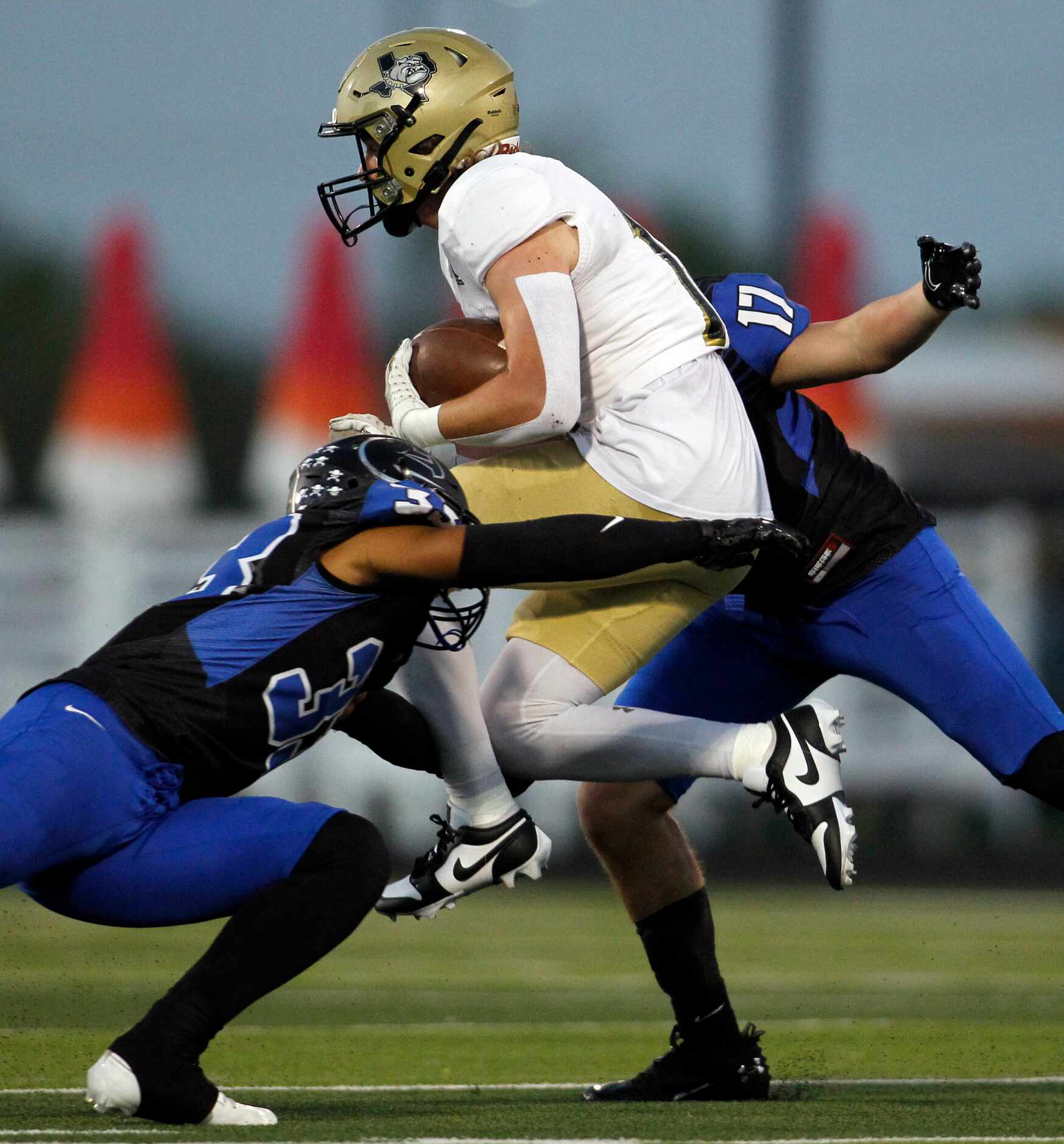 Royse City running back Brennan Anderson (18) tries to leap between North Forney defenders...
