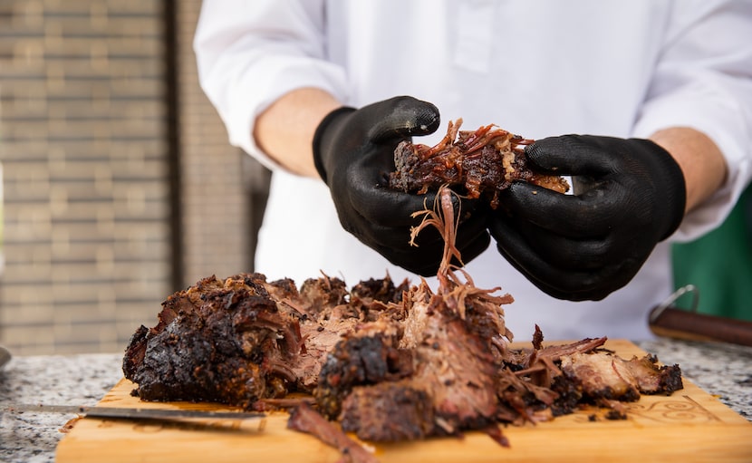 Abdul Hayee prepares to serve brisket he made for the family's Eid celebration on Sunday in...