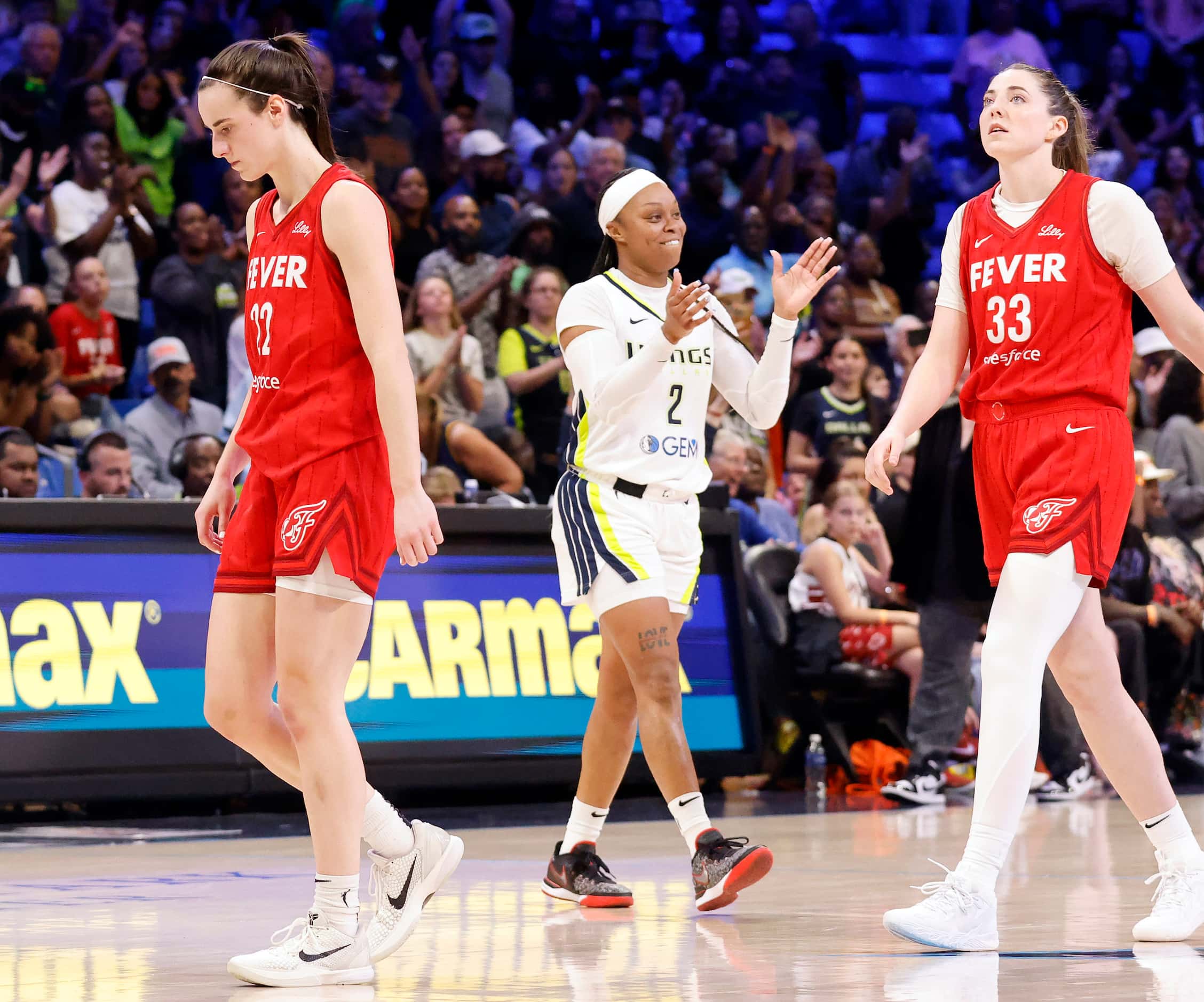 After the game-ending buzzer sounds, Indiana Fever guard Caitlin Clark (22) and forward...