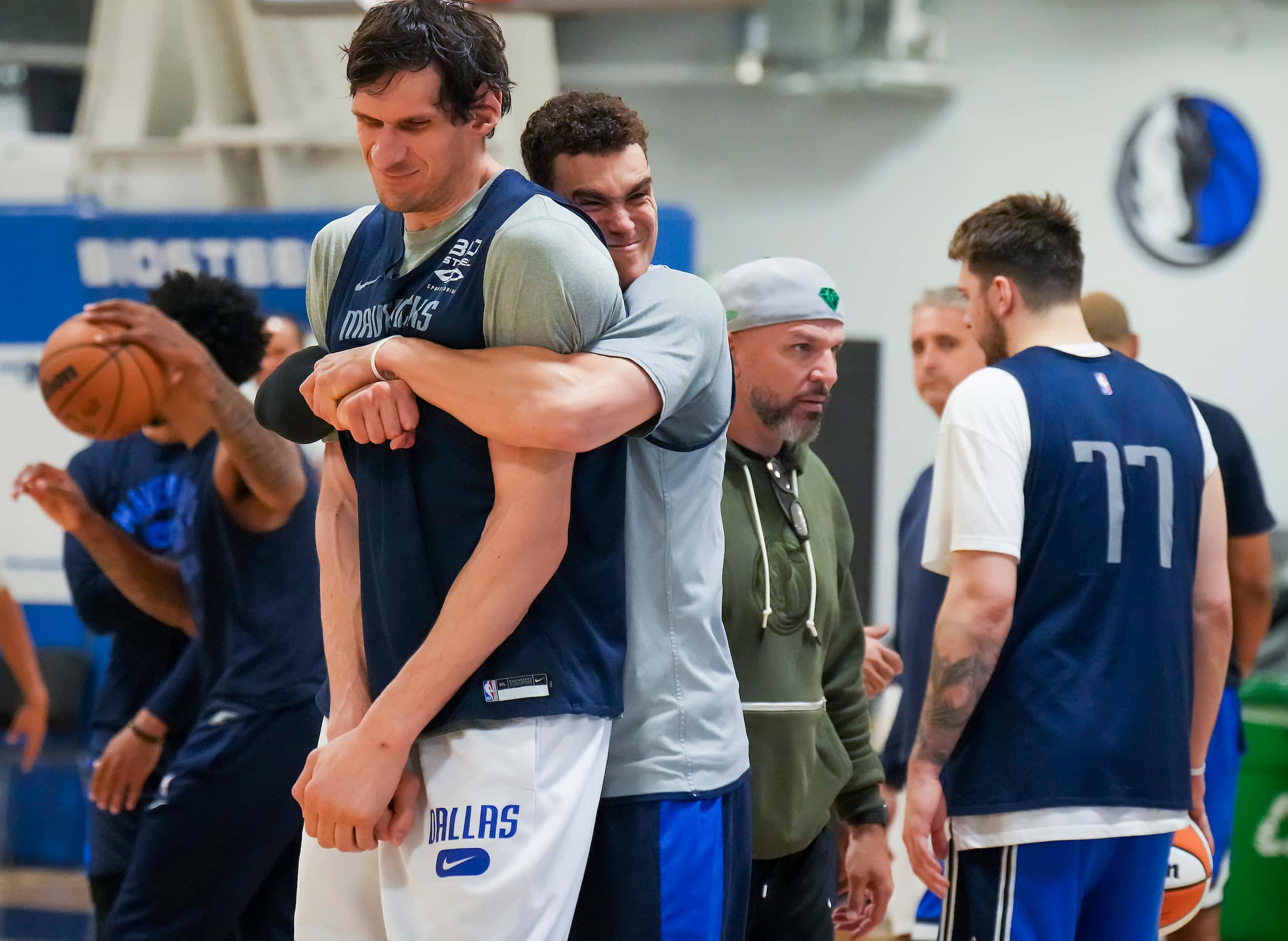 Dallas Mavericks center Dwight Powell wraps his arms around center Boban Marjanovic as the...