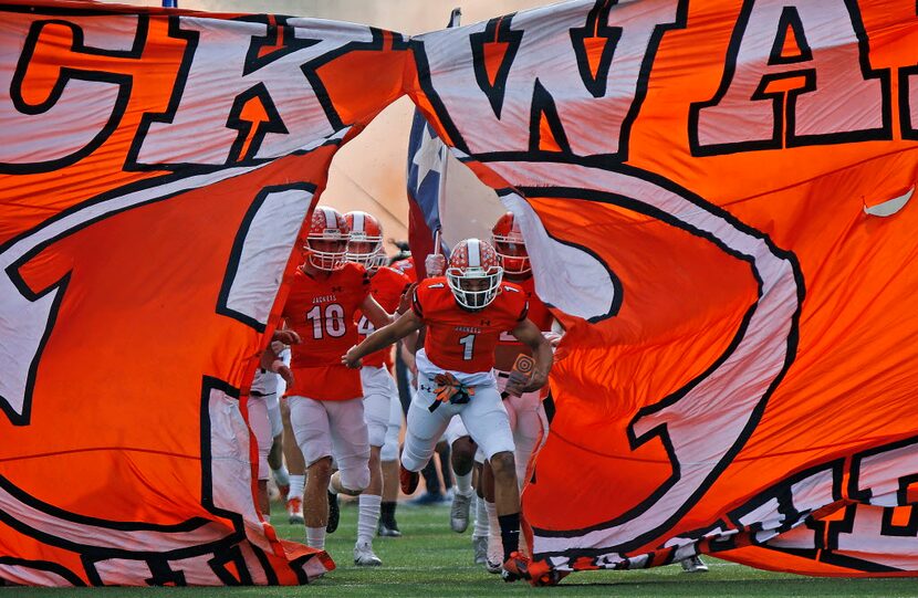 The Rockwall High School football team breaks through their spirit banner upan taking the...