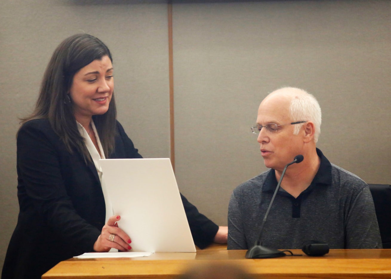 Prosecutor Andrea Moseley shows Mark Stevens a wedding photo of his brother Dave and Patti...