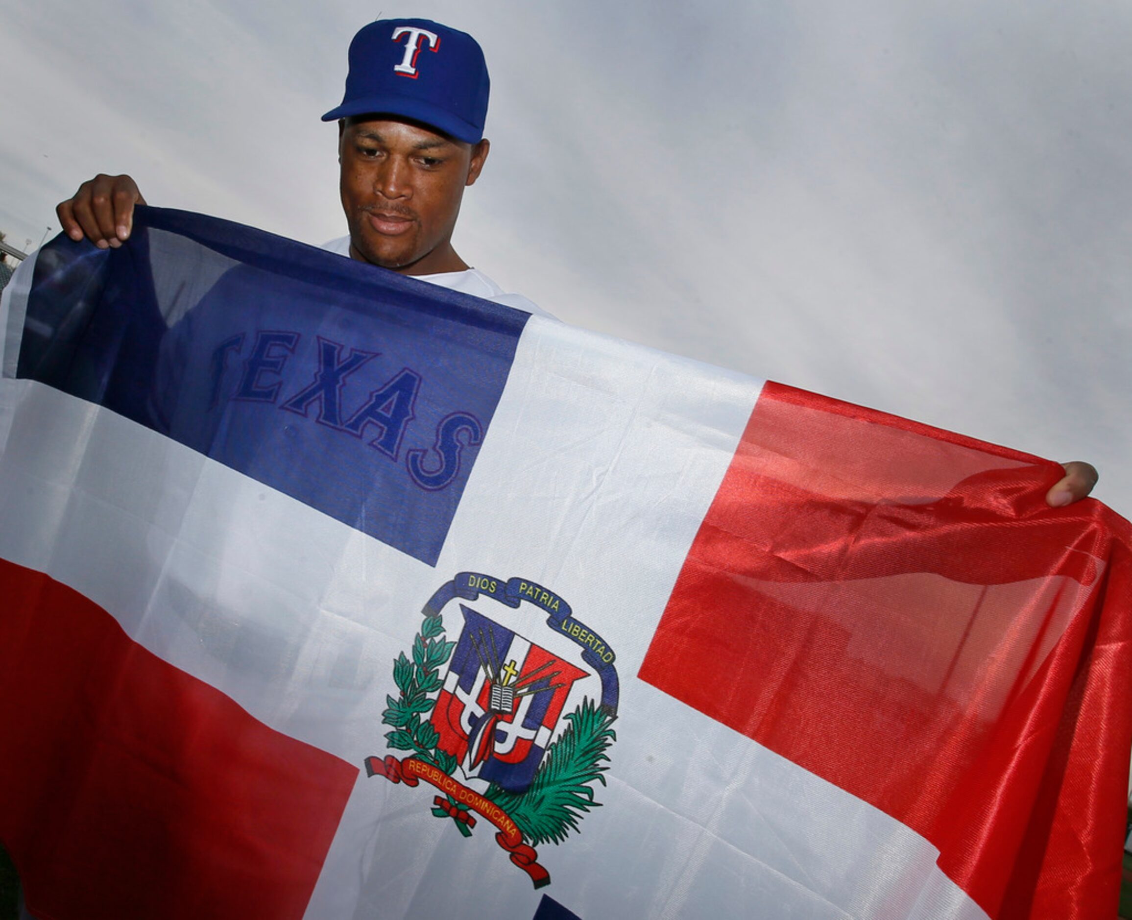 Texas third baseman Adrian Beltre poses with the Dominican Republic flag at photo day during...