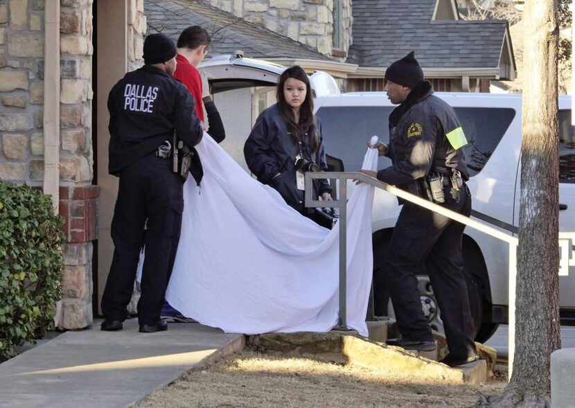 
Dallas police officers used a sheet to cover the doorway as an infant’s body was removed...