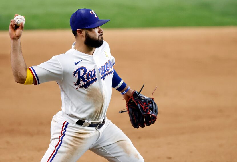 Texas Rangers Isiah Kiner-Falefa (9) fields a hit ball and throws to first during the ninth...