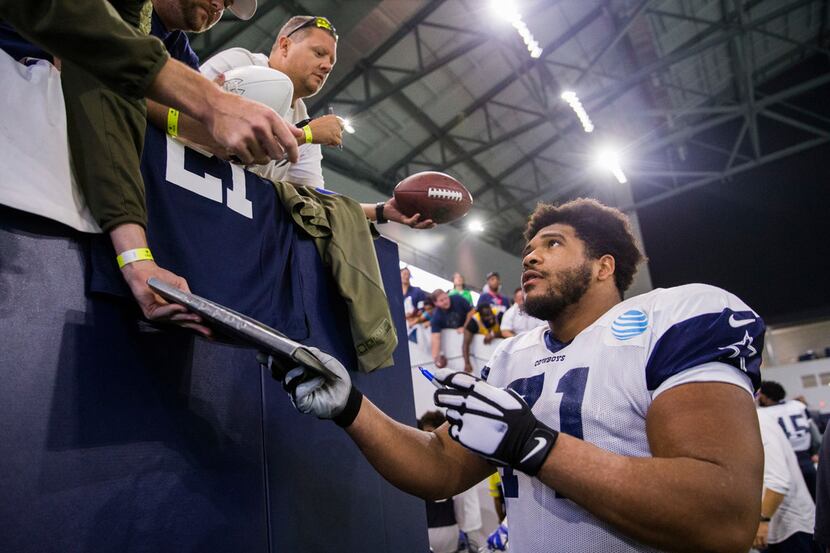 FILE - Dallas Cowboys offensive tackle La'el Collins (71) signs autographs for fans during a...