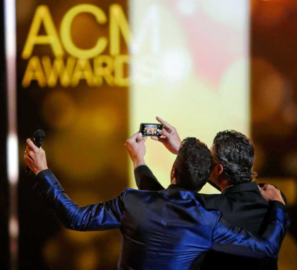 Hosts Luke Bryan (left) and Blake Shelton take a selfie on stage during the 2015 Academy of...