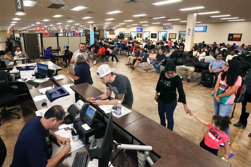 People check in and prepare to sit and wait to get called to get a drivers license or state...